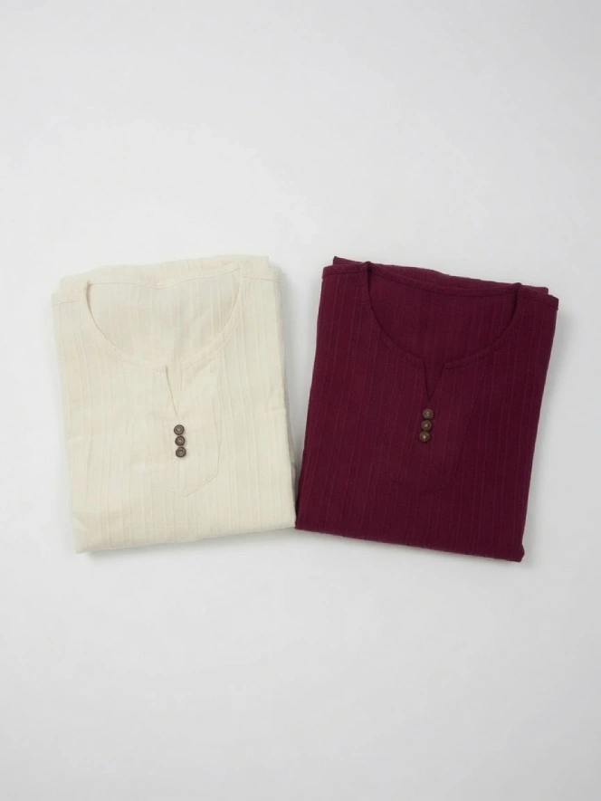 phap-phuc-nam-2026-mau-trang-maukem-maudo - Đồ Lam Đi Chùa Giá Sỉ Two folded knit henley shirts, cream and burgundy, with brown buttons on a white surface.