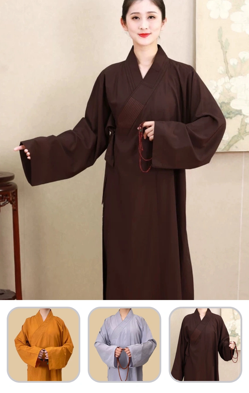 Woman in a dark brown traditional robe with wide sleeves, holding a red beaded bracelet in front of a beige backdrop.