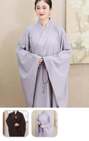 Person wearing a light gray traditional robe with wide sleeves, hands clasped, holding a beaded mala necklace indoors release.